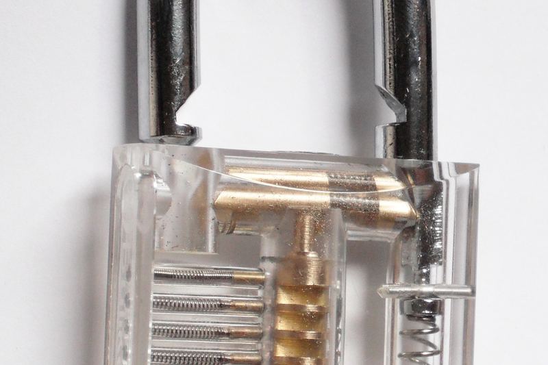 Clear padlock with key showing the pin stack