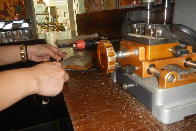 Key being cut and checked on a cutting machine