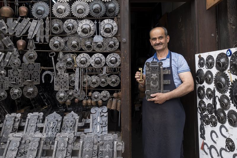 Locksmith standing in a shop lined with key blanks